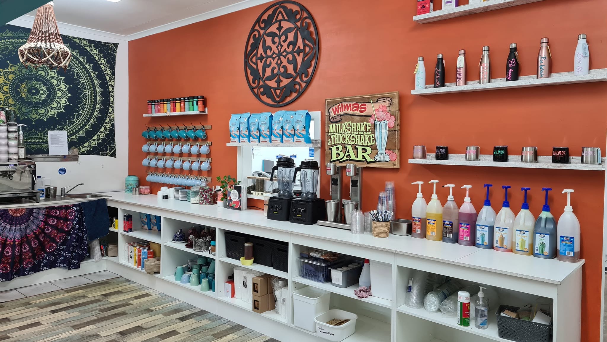 The counter under the orange feature wall, with the hand-painted milkshake and thickshake bar sign