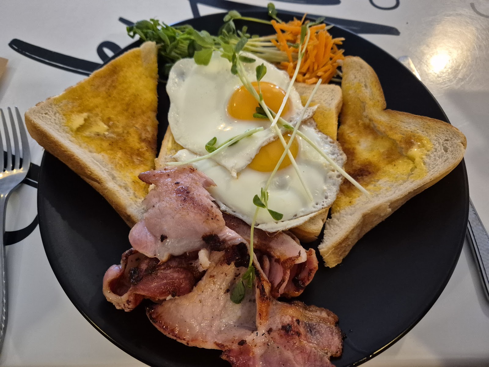 Big breakfast with fried eggs, bacon and toast