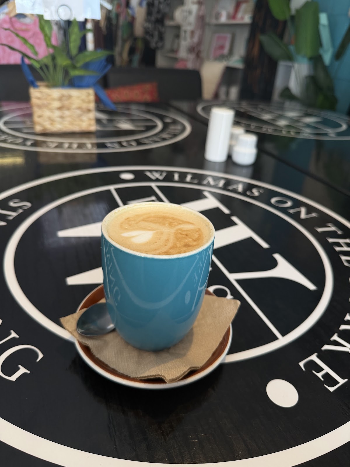 Flat white in a teal cup on the WY roundel table