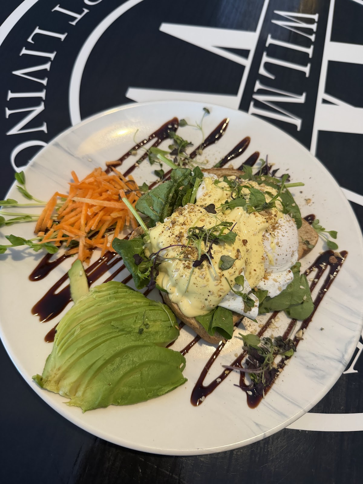 Eggs benedict with smashed avocado on one of the cafe's black roundel tables